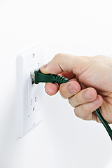 Image showing Hand inserting plug into outlet