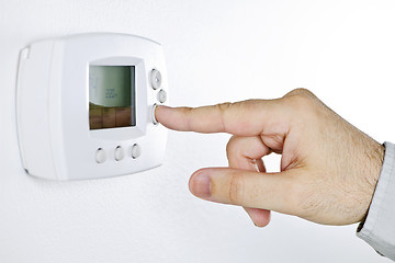 Image showing Hand setting digital thermostat