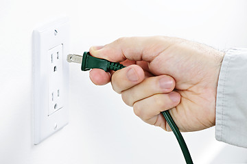 Image showing Hand inserting plug into outlet