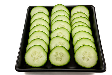 Image showing Sliced cucumber on a black plate