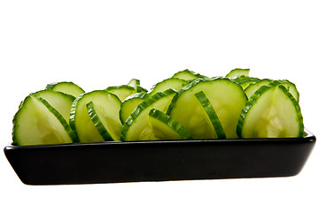 Image showing Sliced cucumber stacked on a black plate