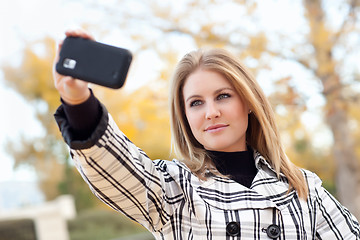 Image showing Pretty Young Woman Taking Picture with Camera Phone