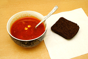 Image showing An overhead view tomator soup with bread