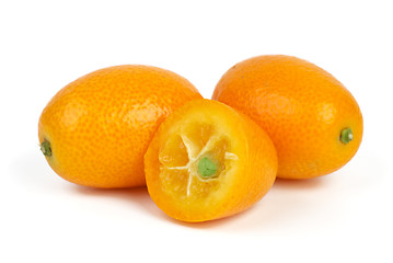 Image showing Two whole and sliced kumquat fruits