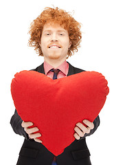 Image showing handsome man with red heart-shaped pillow