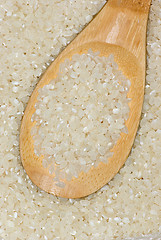 Image showing Wooden spoon with uncooked polished rice