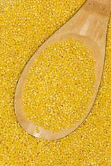 Image showing Wooden spoon with uncooked millet