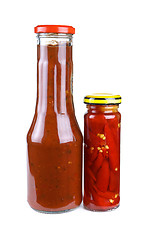 Image showing Bottles with tomato ketchup and marinated red hot chili peppers