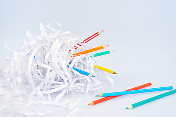 Image showing Colored pencils and shredded paper ball over light blue background