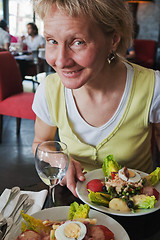 Image showing The woman behind a little table of the Parisian restaurant