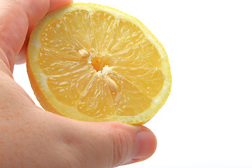 Image showing The hand holding cutted lemons 