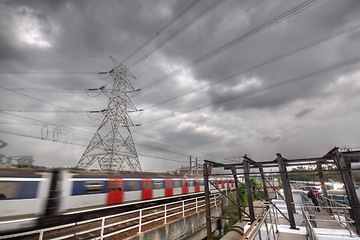 Image showing passenger trains in motion and power tower on background