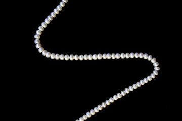 Image showing White pearls on the black silk