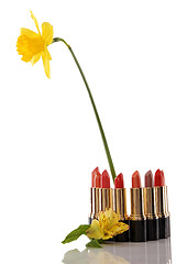 Image showing glamor red shiny lipstick and yellow flower