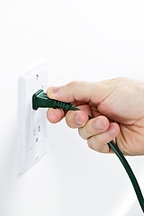 Image showing Hand removing plug from outlet