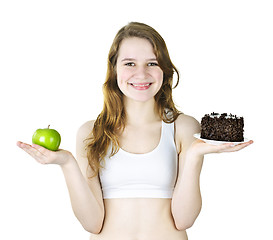 Image showing Young girl holding apple and cake