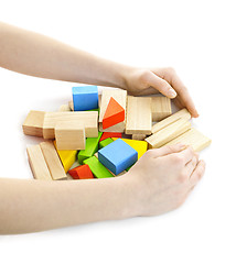 Image showing Hands with wooden block toys