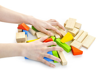 Image showing Hands with wooden block toys