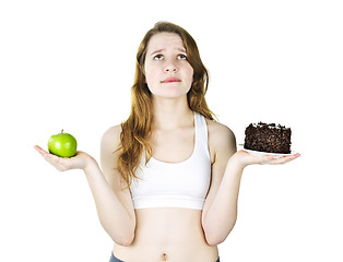 Image showing Young girl holding apple and cake