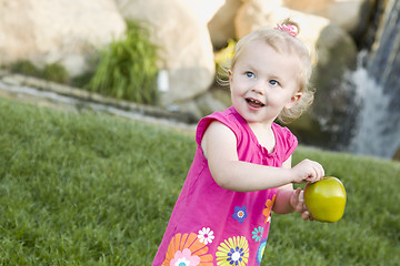 Image showing Smiling Young Girl in The Park Holding Apple