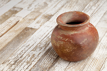 Image showing red clay pot on rustic table