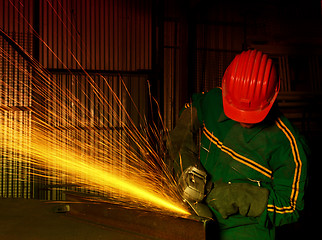 Image showing heavy industry manual worker with grinder 