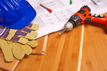 Image showing helmet and blueprint on wood floor