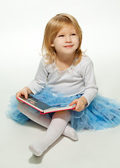 Image showing Small girl reading a book and smiling