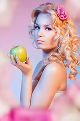 Image showing Curly blond woman with green apple