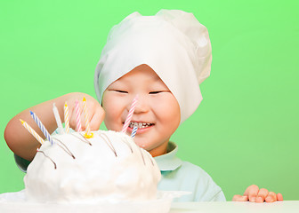 Image showing Boy putting candles in birthday cake