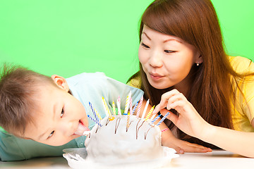 Image showing Boy licks his birthday cake