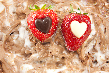 Image showing Two strawberries with chocolate hearts - high dof