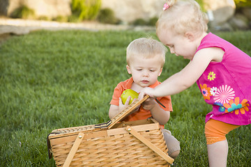 Image showing Brother and Sister Toddlers Playing with Apple and Picnic Basket