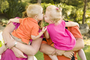 Image showing Mom and Dad Holding Kissing Brother and Sister Toddlers