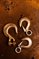 Image showing Rusty crane hooks on metal plate