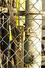Image showing power lines and pipes with steel fence