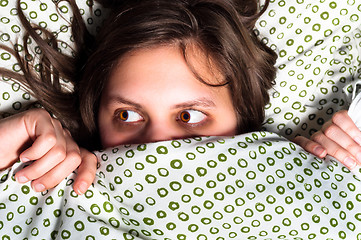 Image showing Young scared girl hiding under blanket