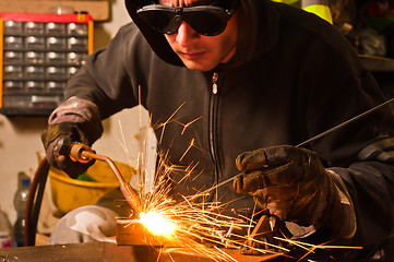 Image showing worker welding with hot flame and sparks