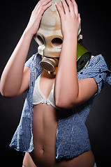 Image showing Girl in gasmask holding her head