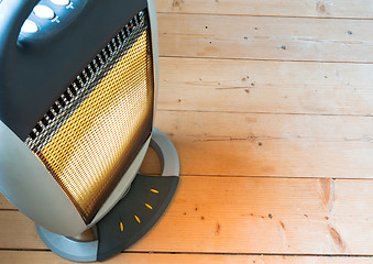 Image showing A halogen or electric heater on wooden floor