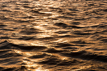 Image showing Waves of water reflecting the sunset