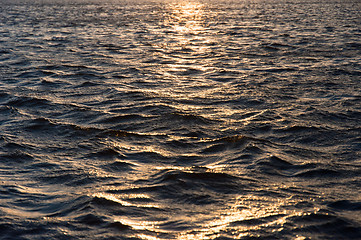 Image showing Waves of water reflecting the sunset