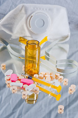 Image showing Medicine spilled out of bottle with syringe and protective mask