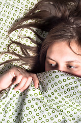 Image showing Girl scared of something under blanket