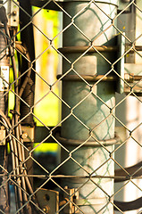 Image showing power lines and pipes with steel fence