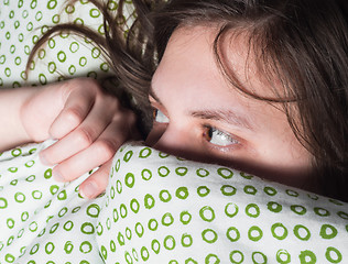 Image showing Girl scared of something under blanket