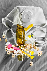 Image showing A protective mask and a medicine bottle with pills and syringe