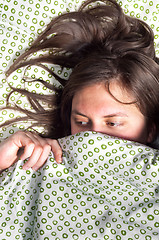 Image showing Young scared girl hiding under blanket