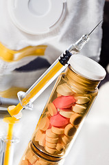 Image showing Medicine glass bottle with pills and syringe with protective mas