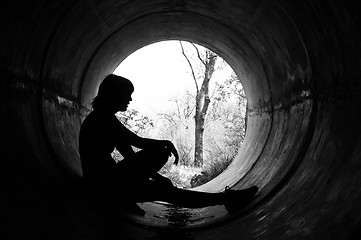 Image showing Silhouette of a young girl in sewer pipe